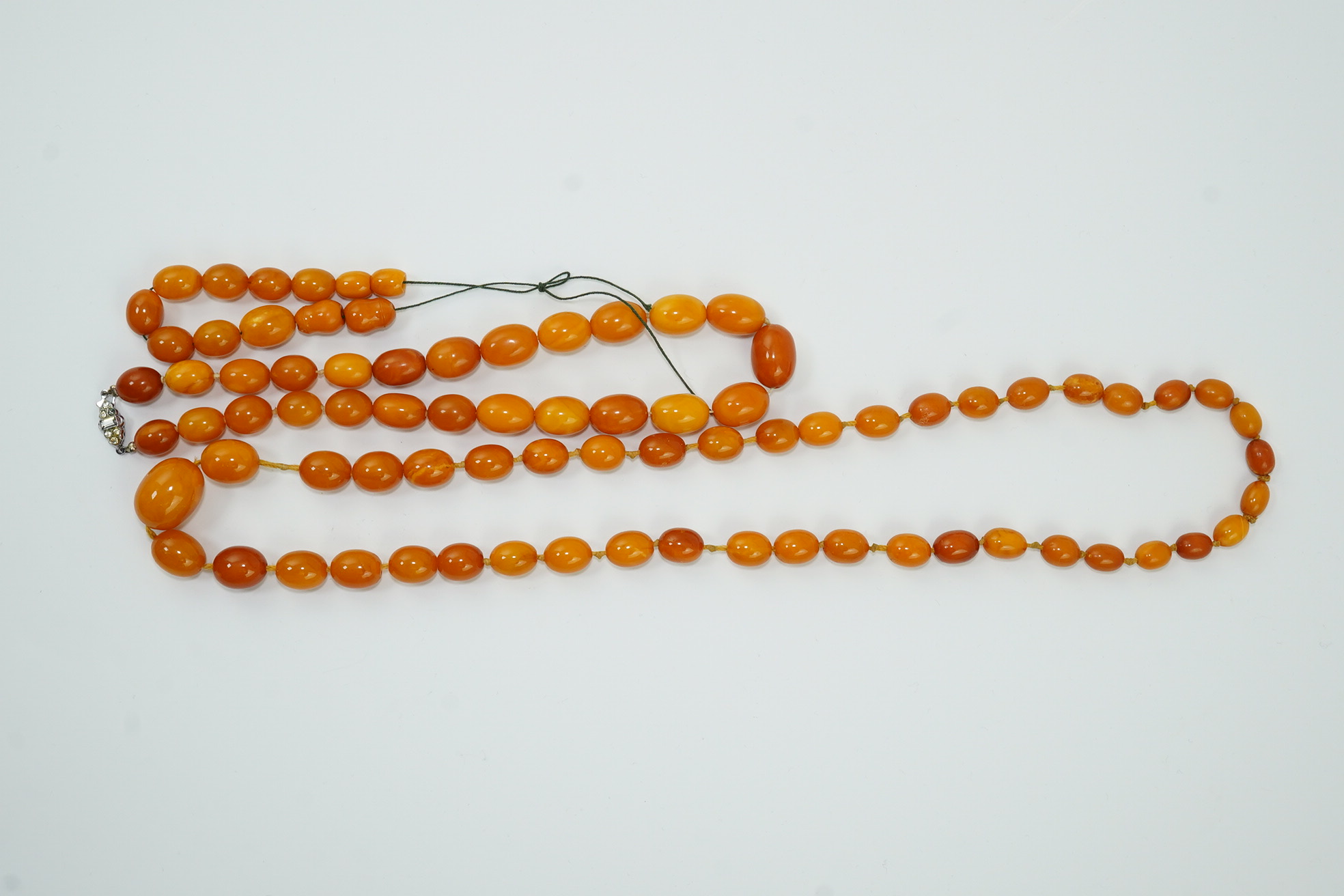 Two single strand graduated oval amber bead necklaces, longest 70cm, and a small group of amber beads strung as a bracelet